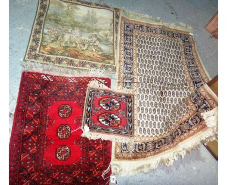 A group of three small Persian rugs and a tapestry.