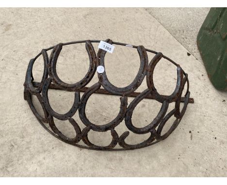 A WROUGHT IRON HAY RACK PLANTER FORMED FROM HORSE SHOES 