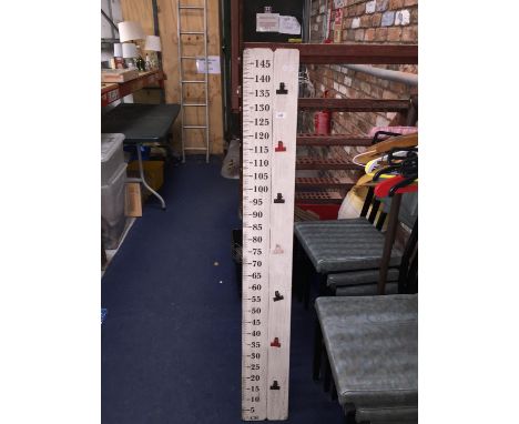 A FAIRGROUND MEASURING STICK MEASURING CHILDREN'S HEIGHT 