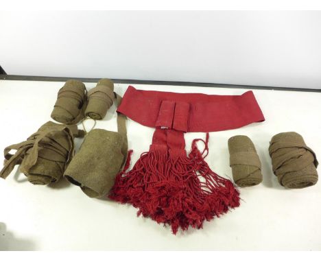 A BRITISH ARMY RED SASH BELT AND THREE PAIRS OF PUTTIS 