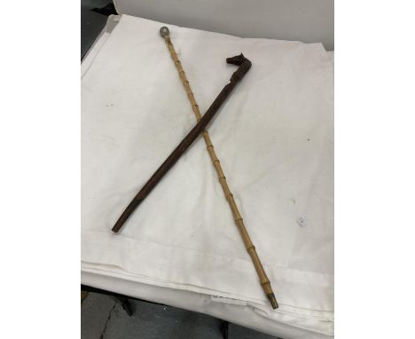 A BAMBOO SWAGGER STICK WITH A WHITE METAL TOP AND A CARVED RIDING CROP WITH A HORSES HEAD HANDLE 