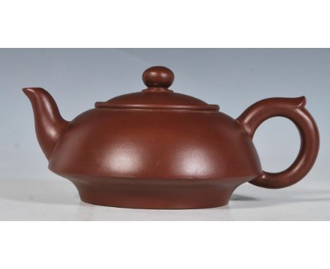 A 20th Century Chinese ceramic brown clay teapot of small proportions having character marks to the base, with a finial lid t
