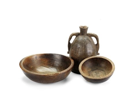 Two turned elm bowls, together with a turned and carved two-handled flask19th century The bowls of typical turned form,   the