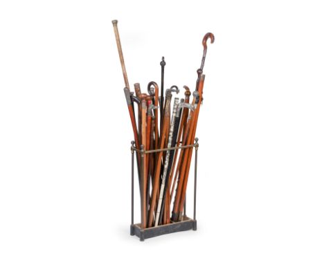 A late Victorian brass stick stand and collection of sticks and canesThe sticks and canes including examples with silver moun