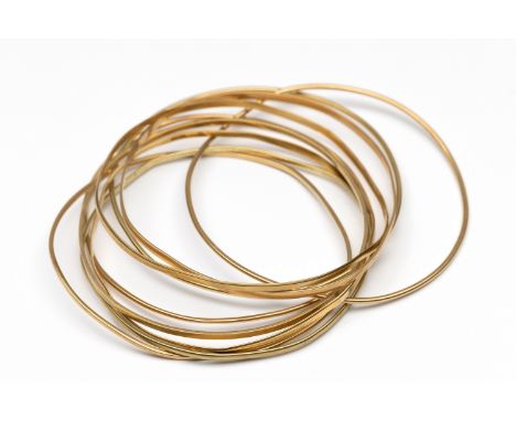 Negen gouden rinkelarmbanden. deels 14 kt. en deel 18 kt. goud bruto 42,6 gr. [9] Nine gold bangles. partly 14 k. and part 18
