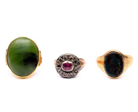 Drie gouden ringen. Eén 14 kt. bezet met nefriet, één 14 kt. met heliotroop en één beneden wettelijk gehalte, met robijn in e