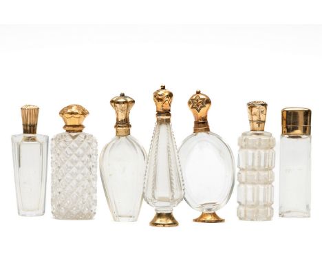Zeven kristallen parfumflacons met gouden montuur, 19e eeuw. Zes van 14 kt., één van 18 kt. Twee stopjes ontbreken. (tin, deu