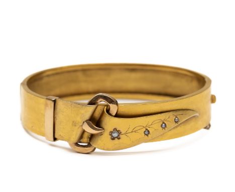 18 kt. Gouden stijve armband, 19e eeuw. De voorzijde gedecoreerd met een gesp en een bloem, bezet met zaadparels bruto 19,8 g