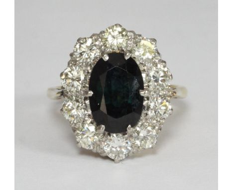 An 18ct gold ring centrally claw set with a faceted oval Australian sapphire, surrounded by 10 diamonds, estimated total diam