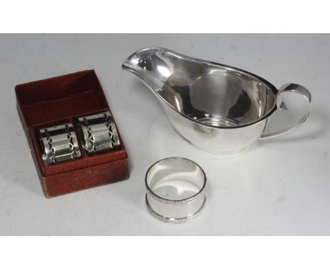 A silver cream boat, hallmarked Birmingham, 1938, together with a cased set of two silver-plated napkin rings and a loose sil