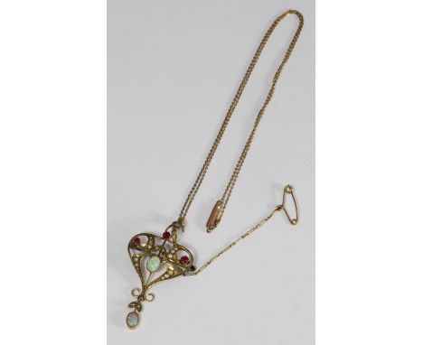 A Edwardian 9ct gold Opal, Ruby and Seed Pearl scrollwork pierced pendant/brooch, with fine necklace chain, 4.03g, in egg-sha