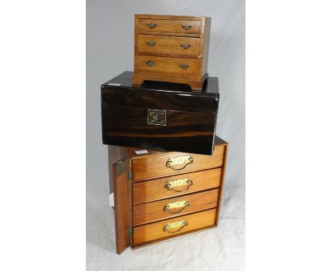 An Edwardian stained walnut table-top collectors cabinet with four drawers and vertical hinged wooden locking panel, 30cm wid