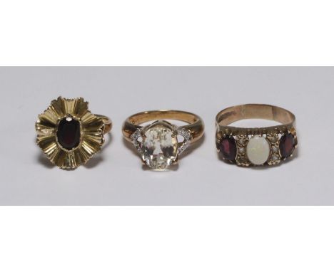 A 9ct gold dress ring set with an oval faceted clear stone, possibly a white sapphire, together with a 9ct gold garnet ring a