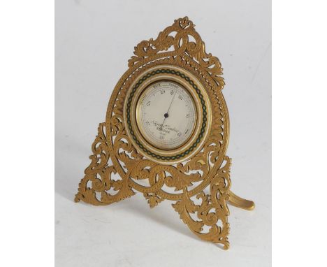 A Negretti &amp; Zambra gilt-metal pocket barometer with silvered dial, displayed in a gilt-metal table stand with pierced, s