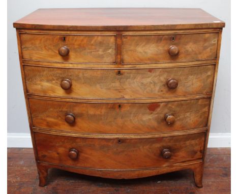 A 19th century bow-front flame-mahogany chest of two short and three long graduated drawers with original turned pulls, escut