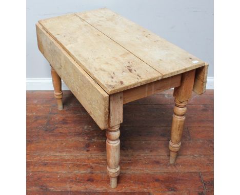 A pine Pembroke style dining table with two drop-leaves, single frieze drawer and raised on turned supports, 107cm long, toge