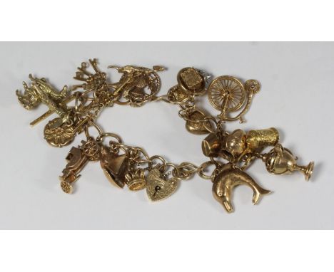 A 9ct gold charm bracelet with a collection of assorted 9ct gold charms including rings, a car, keys and a trophy etc. one ch