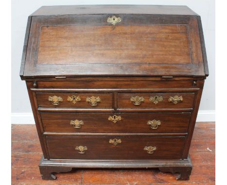 George III stained oak bureau with fall-front enclosing cupboards drawers and pigeonholes and recessed storage well, above tw