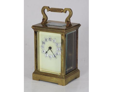 A brass carriage clock, the top with platform escapement, the ivory coloured dial with Arabic numerals denoting hours and rai