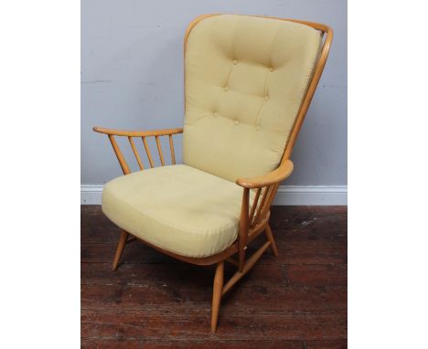 An Ercol Windsor armchair in light beech, with curved stick back and raised on turned supports, together with an Ercol beech 