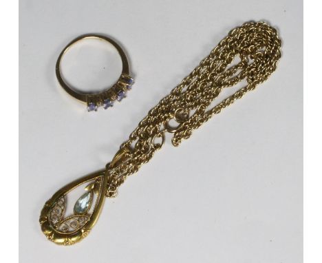 A 14ct gold ring set with four oval purple coloured stones (possibly tanzanite) and three rows of two small diamonds between 