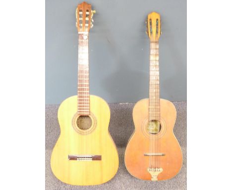 Two acoustic folk guitars, both fitted with six nylon strings, one by Marina, model GK-77, the other a Suzuki model 6F