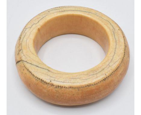 An 18th/19thC African ivory tribal bangle with dot decoration, external diameter 10cm, internal 6cm