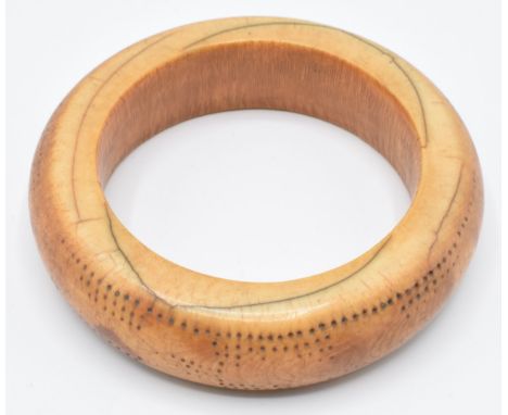 An 18th/19thC African ivory tribal bangle with geometric dot decoration, external diameter 9cm, internal 6.2cm