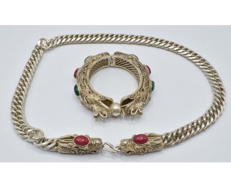 A white metal necklace with dragon head clasp and a bangle depicting two dragons chasing a flaming pearl&nbsp;