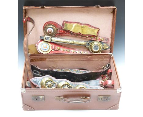 A collection of 19thC heavy horse harnesses and brasses, the leather stained red with heart motifs, ceramic red, white and bl