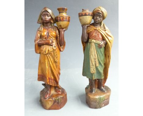 A pair of terracotta blackamoor water carrier figures possibly Goldscheider, with impressed numbers to the bases, 24cm tall