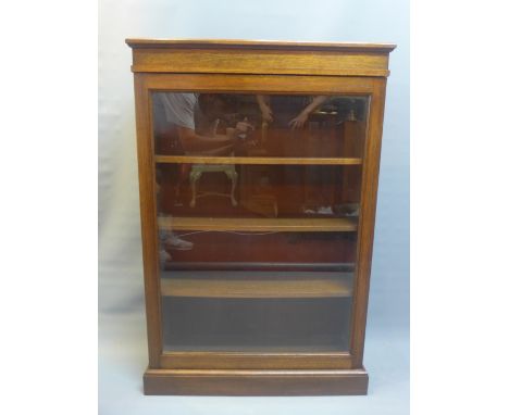 A 19th century oak display cabinet with glazed door enclosing shelf space and raised on stepped base. H-109cm W-72cm D-24cm 