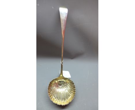 Late 18th / early 19th century large silver ladle, rubbed hallmarks, repousse embossed shell bowl with gilt washed interior, 