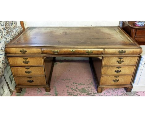 PEDESTAL DESK, Georgian style walnut with an inlaid tooled leather top and five drawers including shaped top drawers, the mid