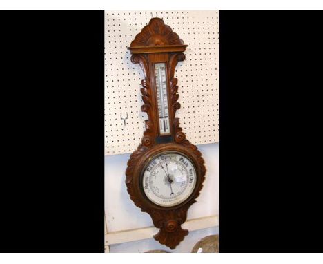 A Victorian carved oak barometer with leaf carving