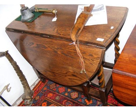 An oak gate leg table on barley twist supports