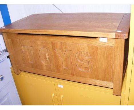 A contemporary light oak toy chest with safety sprung lid 
