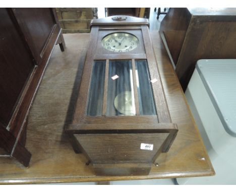 A 1930s oak cased wall clock
