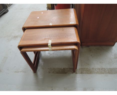 A vintage teak nest of three tables of stylised form
