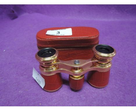 A vintage pair of opera glasses in a red leather and gilt style 