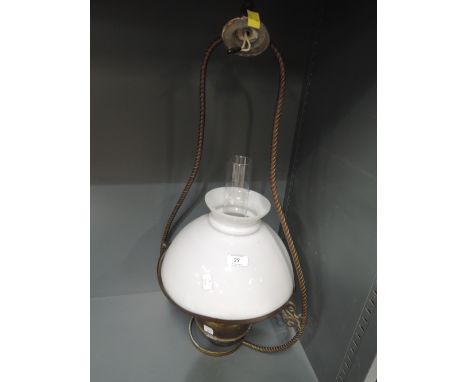 A vintage oil burning lamp with ceiling fitting and milk glass shade
