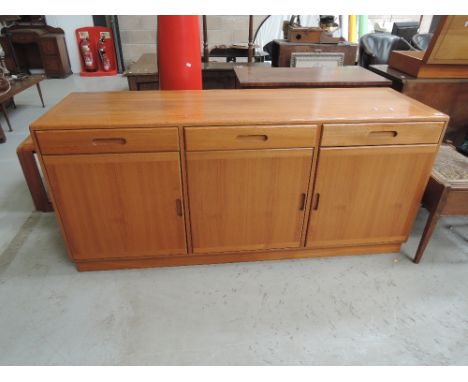 A vintage sideboard, having three frieze drawers and triple cupboard under , stamped A to reverse, similar to G plan 