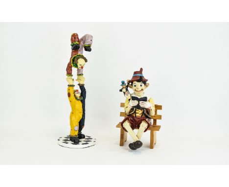 Pinnochio Resin Figure A whimsical figure of pinnochio and Jiminey Cricket reading whilst seated on small wooden bench. Also 