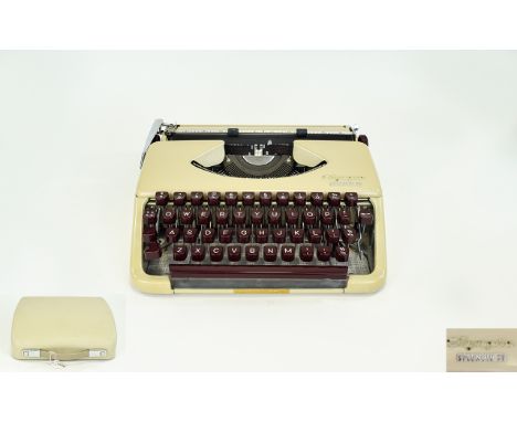 Vintage Olympia Splendid 33 Typewriter Portable typewriter in original cream plastic carry case. Cursive script, maroon keys,