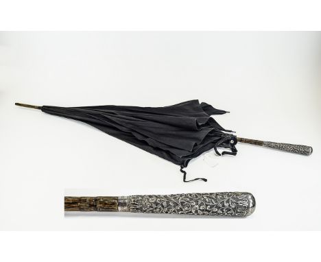 Antique Umbrella Large late 19th century umbrella of black cotton and wood construct with ornate silver tone handle. Finely d