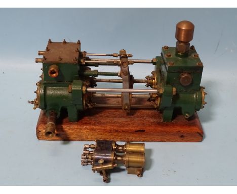 An unmarked twin-cylinder horizontal steam engine and a small brass engine part, (2). 