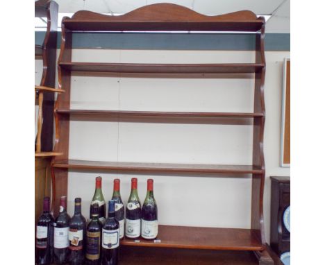 A floor standing mahogany open shelf unit of five drawers 