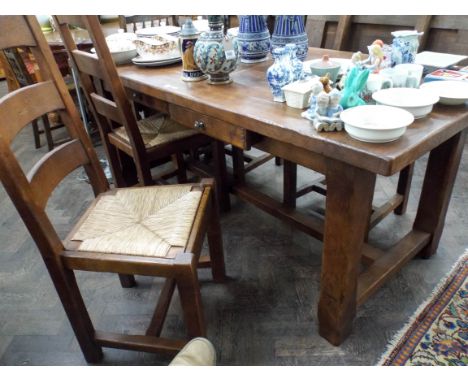 A French oak dining table with two additional leave and four chunky ladder back dining chairs with rushed seats 