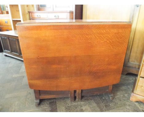 A 1930's oak drop leaf, gate legged dining table with cupboard end 