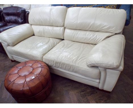 A two seater ivory leather sofa and a brown leather chequer board pattern footstool 